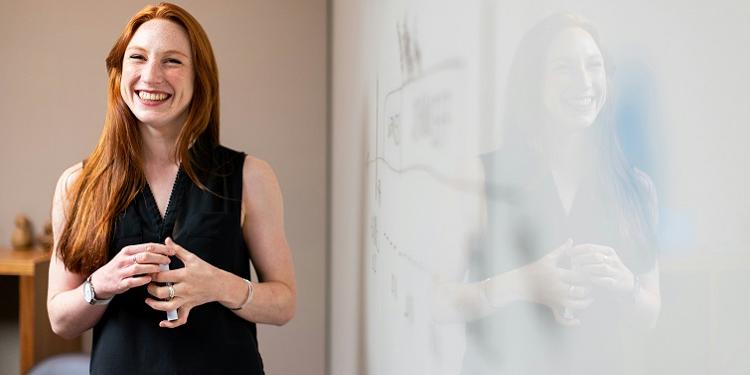 Teacher standing at whiteboard in a classroom 750x375